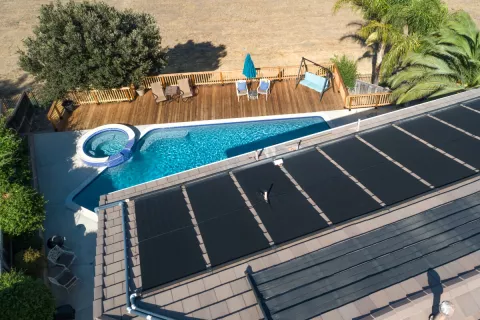 Flachkollektoren für Solarthermie auf einem Dach mit Pool.
